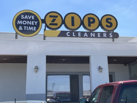 Dry cleaning store with large yellow letters on top of the building that reads ZIPS.