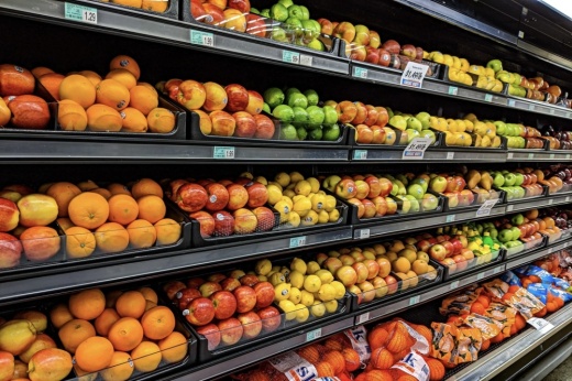 Fruits and vegetables on shelves in a grocery store.