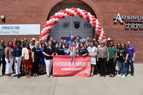 Vanessa Walls, president of the Northern Market for Children's Health, cuts the ribbon during a ceremony on Aug. 4 surrounded by Frisco ISD faculty, school board members and community leaders. (Grant Johnson/Community Impact Newspaper)