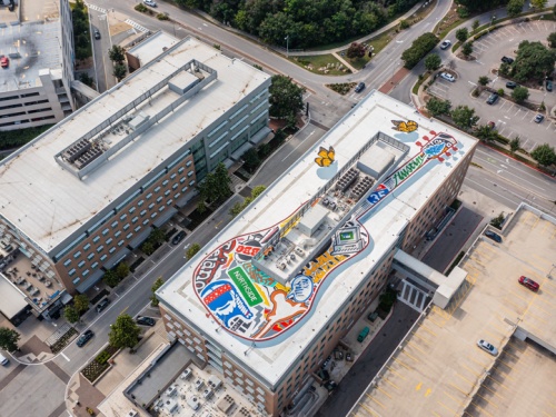 Drone view of the rooftop of a building with a giant guitar painted across it.