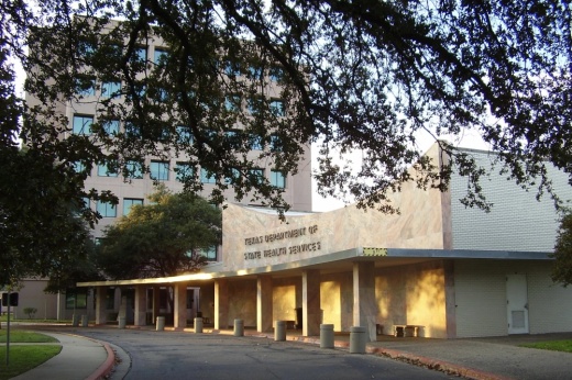 Building behind trees reads 'Texas Department of State Health Services'
