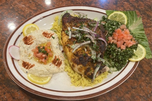 The grilled chicken plate ($16), which includes grilled chicken with rice, hummus and salad, is among the most popular dishes at Rumaan Mediterranean Cuisine. (Zacharia Washington/Community Impact Newspaper)