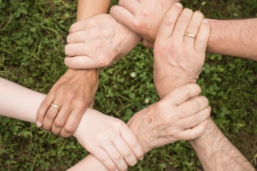 people holding arms in a circle