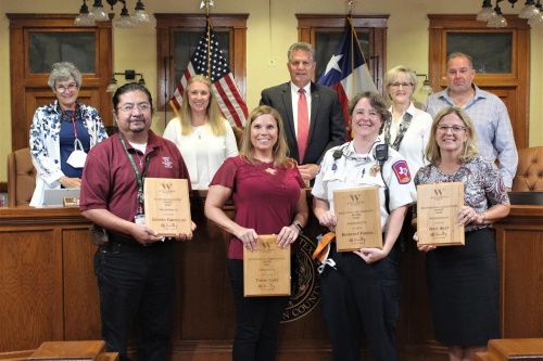 People standing with their plaques in a court
