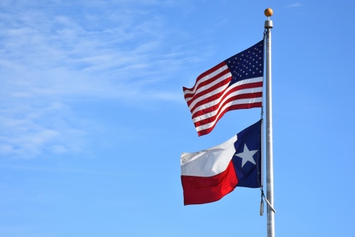 An American flag and the Texas flag on a flagpole.