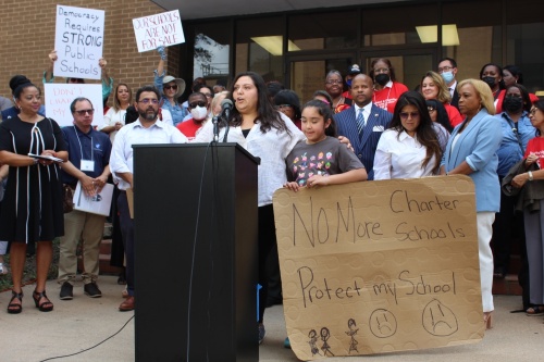 Christina Quintero, a parent of two Houston ISD students, speaks against a charter school partnership proposal at an Aug. 16 rally with her daughter, Tina, at her side. (Shawn Arrajj/Community Impact Newspaper)