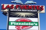 A retail sign showing "Las Fuentes" in red text over "Mexican Restaurant" in white block letters on a black background. Underneath, a second sign shows "Pizzaiolo's" in white block letters on a green banner, on top of a red circle with a red pizza slice with the white text "gourmet pizza," all on a white background