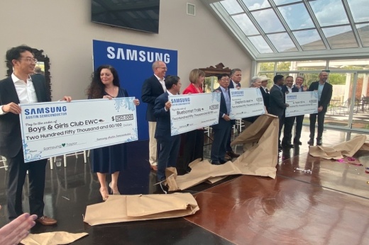 As part of a media event put on by Samsung, local, county, state and national officials joined company executives to present oversize checks of $250,000 each to area charities. (Brian Rash/Community Impact Newspaper)