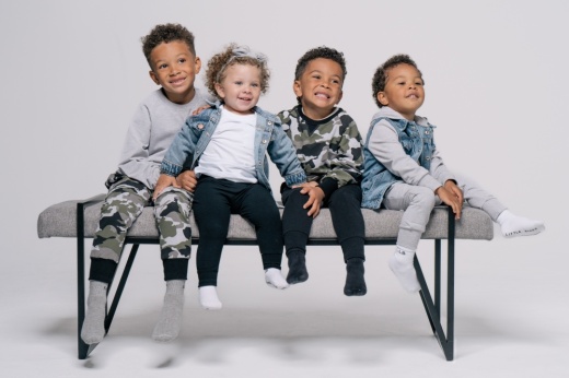 Four boys posing on a bench in Little Bipsy clothing.