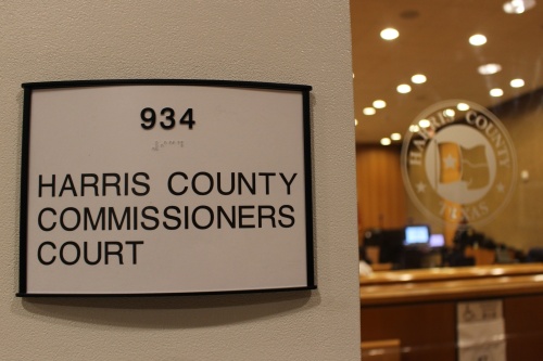 This is a sign outside commissioners court, with the court visible through a glass window in the background.