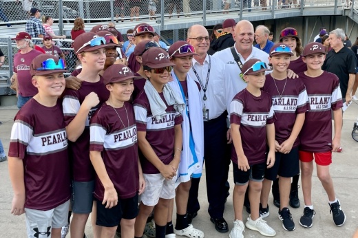 The Pearland Little League team poses with the Pearland Police and Fire departments chiefs. (Andy Yanez/Community Impact Newspaper)