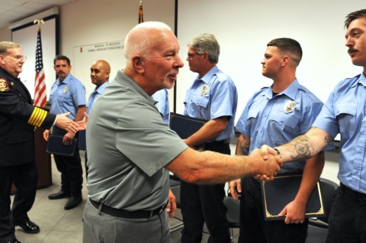 ESD 10 Commissioner Larry Smith and Fire Chief Jeff Hevey congratulate the 12 new firefighters on Aug. 19. (Courtesy Lt. Walter Sassard/Magnolia Fire Department)