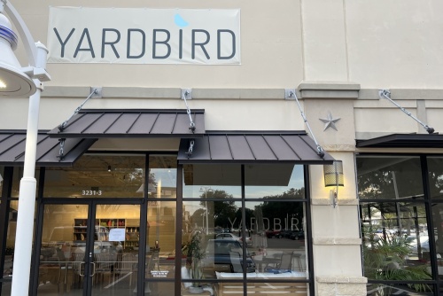 Storefront of Yardbird in Frisco with the store sign above an awning and entrance.