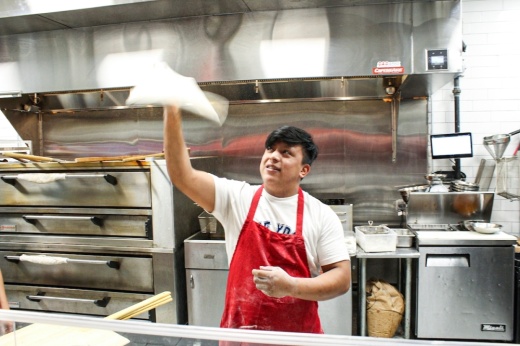 man tossing pizza dough