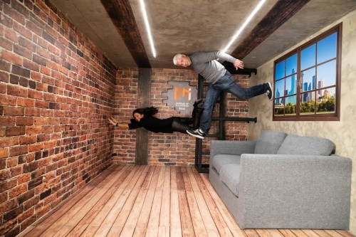 Sofa in a room with two people standing on a side wall