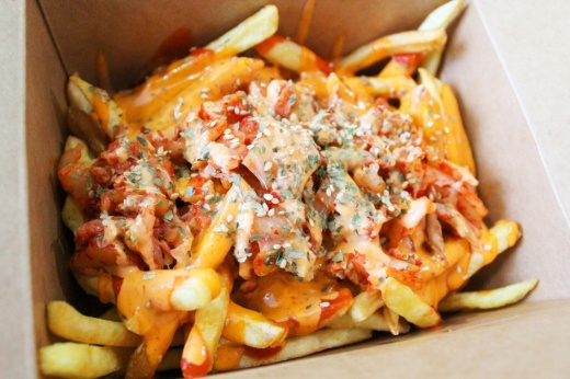Korean fries ($6): Crispy french fries are piled high with kimchi, sriracha and spicy mayo in this customer favorite. (Emily Lincke/Community Impact Newspaper)