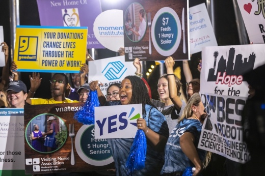 crowd of people holding signs related to North Texas Giving Day