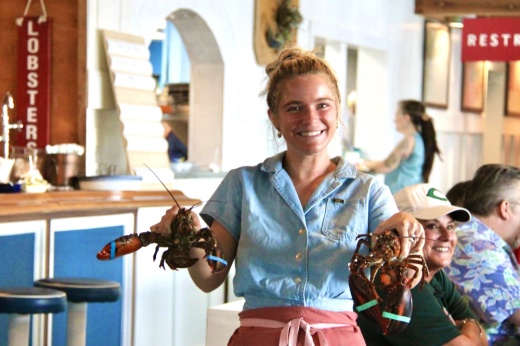 Woman holding two live lobsters
