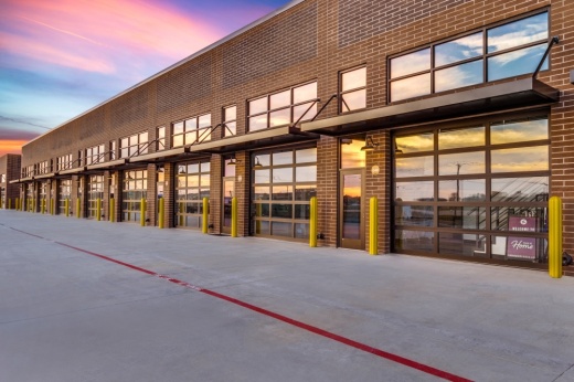 Exterior of an Urban Garages building with multiple identical glass garage doors.