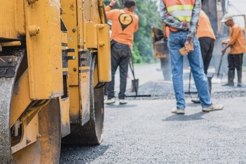 Construction workers repair road.
