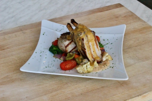 The double-cut smoked pork chop ($29) is brined, smoked and grilled and served with seasonal harvest vegetables, cannellini beans and roasted tomato.