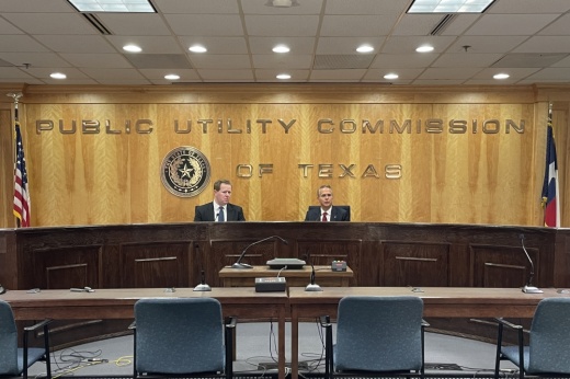 Two men speak at a news conference at PUCT headquarters