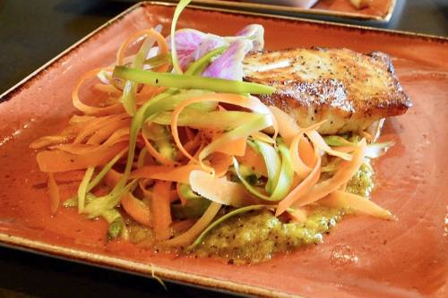 Halibut steak: A new entree on the menu is an 8 oz. steak of halibut topped with shaved carrots, asparagus and watermelon radishes, served with a side of roasted yellow bell pepper coulis and capers. ($25) (Hunter Terrell/Community Impact)