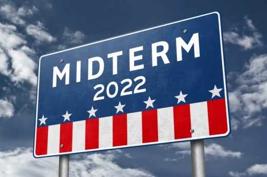 This is a highway sign stylized in American flag colors that reads "MIDTERM 2022" in white against a blue backdrop.