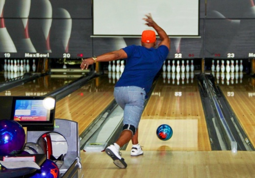 A patron of Max Bowl in Humble spins the ball down the lane in hopes of securing a strike for his team in the bowling alley’s senior league. (Wesley Gardner/Community Impact)