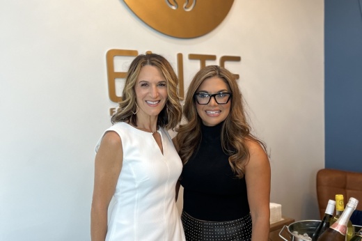 Two women standing in front of an office background.