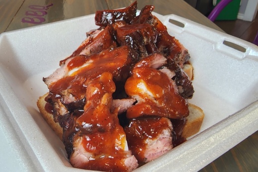 The rib tips ($11) is a staple at The Purple Pig BBQ. This meal includes pork rib tips topped with the signature barbecue sauce and paired with slices of bread. (Jarrett Whitener/Community Impact)