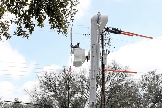 An Austin Energy employee works on a power line