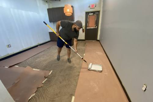 Man rolling paint on new floor. 