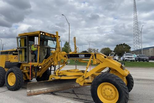 A tractor with a plow, used by TxDOT during winter weather