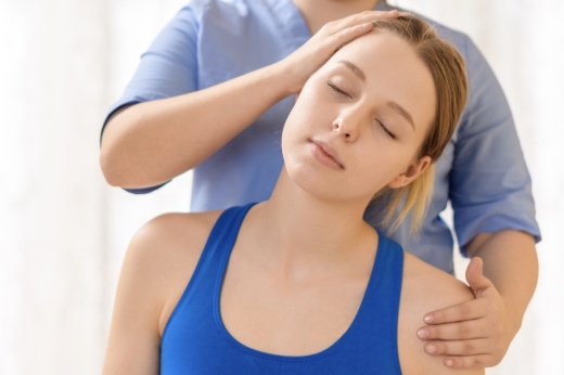 Female a chiropractor adjusting patients neck.