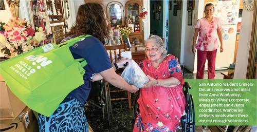 San Antonio resident Cristela DeLuna receives a hot meal from Anna Wimberley, Meals on Wheels, corporate engagement and events coordinator. Wimberley delivers meals when there are not enough volunteers. (Tricia Schwennesen/Community Impact)