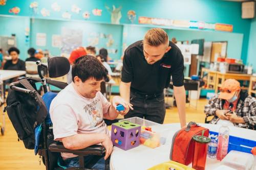 Collin Prusak, The Village Centers director of operations, assists a client with a project at the nonprofit’s day center.(Courtesy The Village Centers)