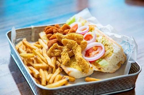 Pipeline Po-boys ($12.99-$14.99): These sandwiches can be ordered with shrimp, catfish, crawfish or oysters, and are served with remoulade sauce, lettuce, red onions, tomatoes and fries. (Courtesy Sharky's Waterfront Grill)