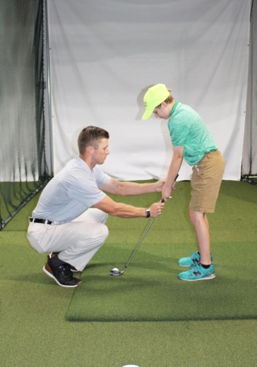 Golf teacher working with student
