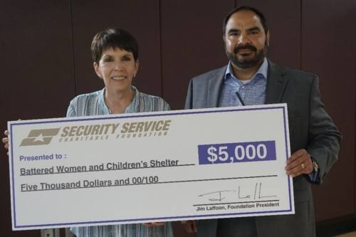 Mark Jimenez (right), vice president of solution analysis and design senior management for Security Service Federal Credit Union, presents Marta Pelaez, president and CEO for The Battered Women and Children’s Shelter, with a donation for $5,000. (Courtesy Security Service Federal Credit Union)