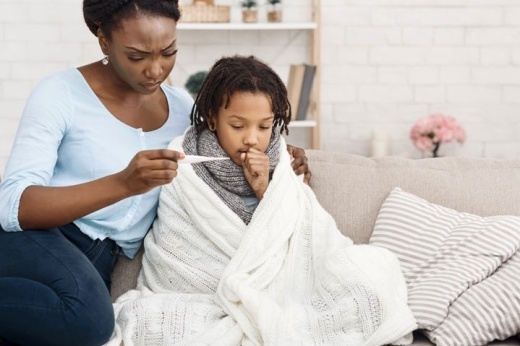 A woman checks her child's temperature.
