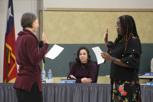 Leander ISD board of trustees President Trish Bode (left) swears Place 5 Trustee Sade Fashokun into office. (Grant Crawford/Community Impact)