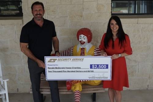 Travis Pearson, CEO of Ronald McDonald House Charities of San Antonio, and Jennifer Othman, director of marketing and development for Ronald McDonald House Charities of San Antonio, receive a $2,500 check from Security Service Charitable Foundation. (Courtesy SSCF)