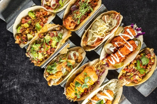 several tacos lined up on metal plate