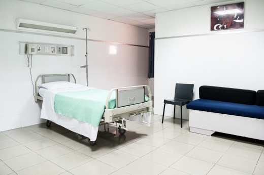 A hospital bed inside a white room.