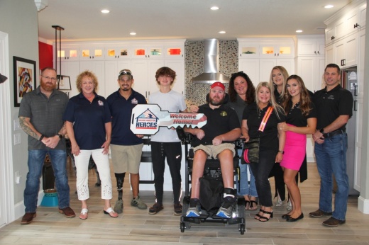 Representatives from Building Homes for Heroes and Superior Home Renovations joined Anthony, Ivonne and AJ Thompson (center) to celebrate the renovations. (Wesley Gardner/Community Impact)