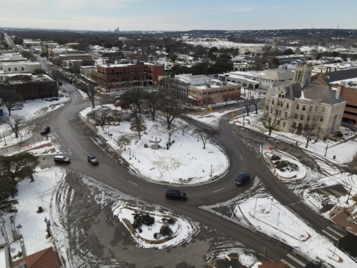 The weather forecast predicts freezing temperatures but clear skies as of Dec. 19. This drone photo shows downtown New Braunfels during Winter Storm Uri in 2021. (Community Impact staff)