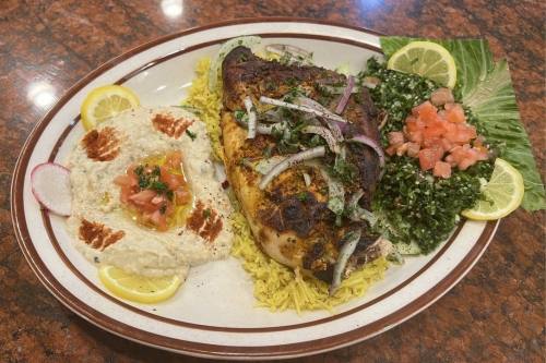 The grilled chicken plate ($16), which includes grilled chicken with rice, hummus and salad, is among the most popular dishes at Rumaan Mediterranean Cuisine. (Zacharia Washington/Community Impact)