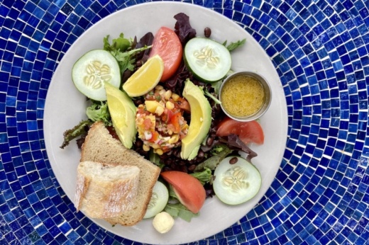 salad on white plate on blue tile table