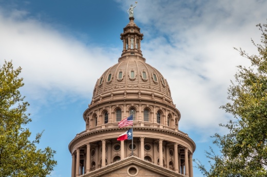 This is a picture of the Texas State Capitol building in Austin, with the Texas and USA flags flying in front.
